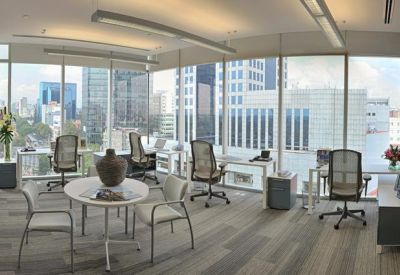 Spacious shared office with floor-to-ceiling windows overlooking the city skyline.