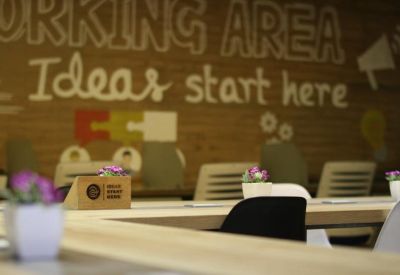 Close-up of a collaborative working area wall featuring the text Ideas start here and potted plants.