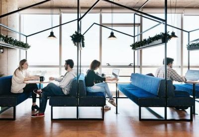 People working in modern booth seating under black house-shaped frames.