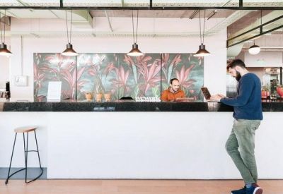 Sleek white reception desk with tropical mural and pendant lighting.