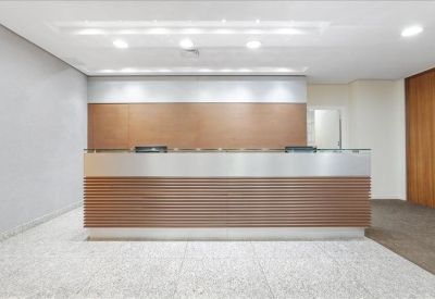 Minimalist professional reception desk with wood paneling and bright overhead lighting.