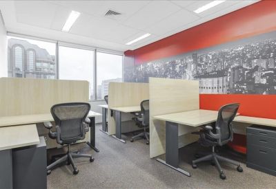 Modern workspace featuring partitioned desks and a vibrant red feature wall with city graphics.