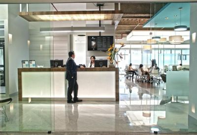 Bright modern reception area with a long white desk and glass partitions.