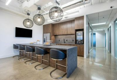 Modern kitchen breakout area with dark wood cabinetry and orb pendant lights.