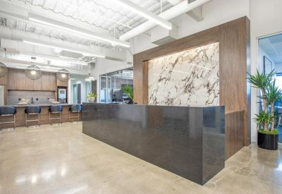 Reception area featuring a dark grey stone desk and marble-patterned feature wall.