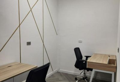 Private office featuring gold geometric wall details and ergonomic black chairs.