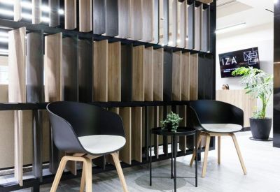 Reception waiting area with modern black chairs and a textured wood-panel feature wall.