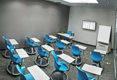 Training room featuring blue chairs with integrated swivel desks and whiteboard.