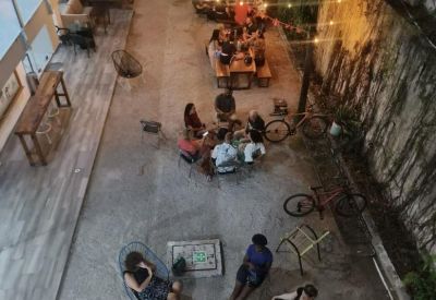 High-angle view of an evening social gathering in a courtyard with string lights.