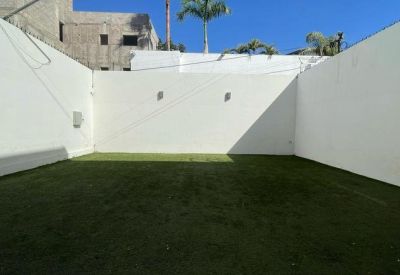 Rooftop terrace with artificial grass and white walls at Octava Workspaces.