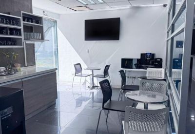 Breakout area with coffee station, high-top tables, and wall-mounted TV.