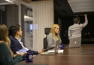 Collaborative meeting in progress within a dark-toned conference room.
