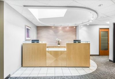 Modern reception area with a light wood desk and curved ceiling lighting.