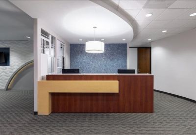 Professional reception area with a dark wood desk and blue feature wall.