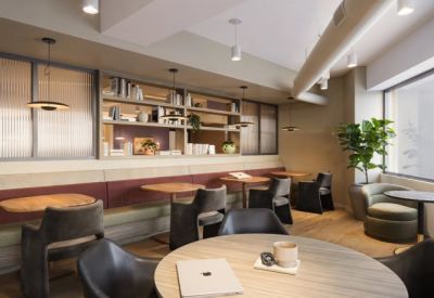 Breakout area with built-in booth seating, bookshelves, and round cafe tables.