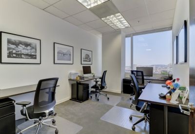 Bright corner office suite with multiple workstations and expansive city views.
