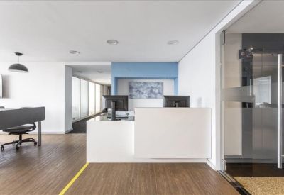 Bright reception area featuring a white minimalist desk and blue feature wall.
