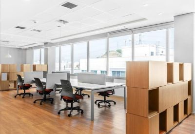 Open-plan office area with modular wooden shelving units and ergonomic workstations.