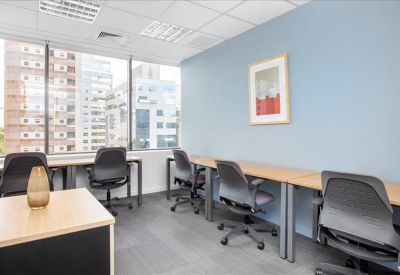 Bright shared workspace with wooden desks and blue accent wall.
