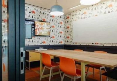 Modern meeting room with a wooden table, orange chairs, and patterned wallpaper.