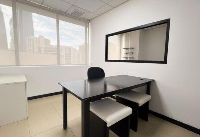 Private internal office with a black desk, stools, and a large window overlooking the city.