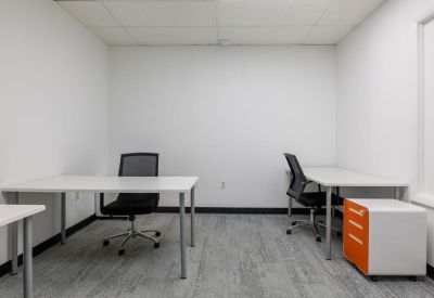 Private two-desk office suite with white walls and a bright orange storage cabinet.