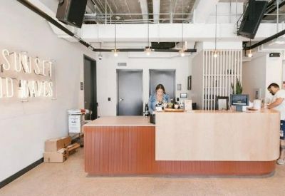 Modern wooden reception desk with light-up wall signage.