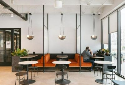 Breakout area featuring orange banquette seating and round cafe tables.