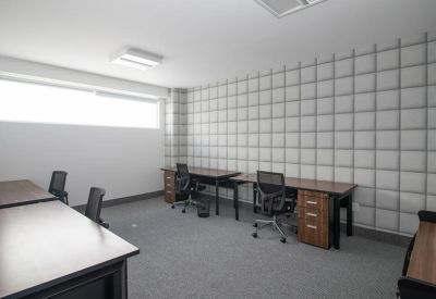 Multi-desk workspace with a geometric patterned acoustic wall.