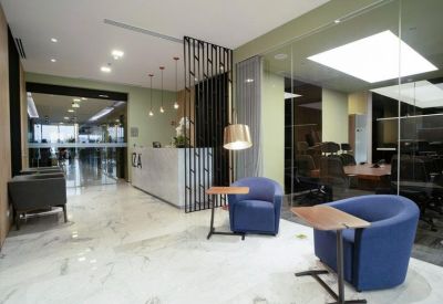 Modern lobby with blue velvet armchairs and a sleek marble floor.