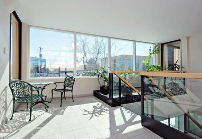 Sun-drenched breakout area with wrought iron seating and glass railings.