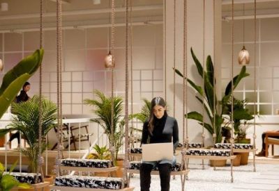 Coworking space featuring unique hanging swing seats and a professional working on a laptop.