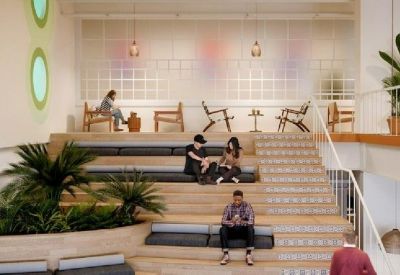 Stepped wooden amphitheater seating area in a bright atrium for informal meetings.