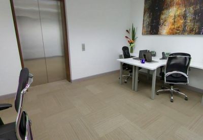 Private office suite with two desks and a large abstract painting.