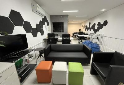 Breakout area with a black leather sofa, colorful ottomans, and a blue beanbag.