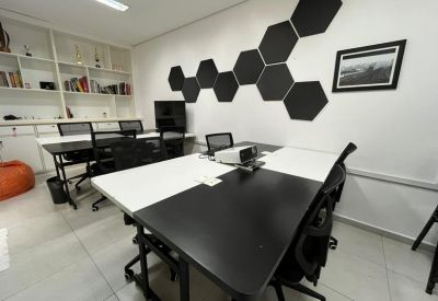 Modern meeting table with integrated tech and a background of white bookshelves.