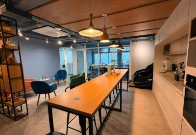 Breakout area with a long high-top wood table and kitchen facilities.