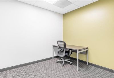 Private internal office with a grey patterned carpet and a yellow feature wall.