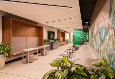 Lounge area with cozy wooden booths and stylish tropical wallpaper.