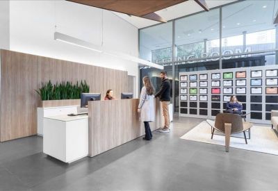 Modern lobby area with a wooden reception desk and a stylish white counter.