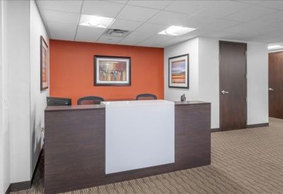Professional reception desk with a white front and a warm orange backdrop.