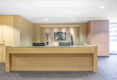 Bright wooden reception desk with minimalist floral arrangements and artwork.