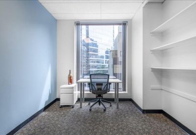 Private office with a blue feature wall, shelving, and city views.