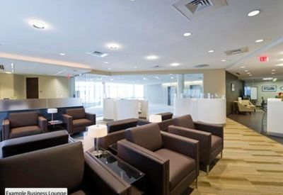 Bright lobby lounge with brown leather armchairs and light wood flooring.