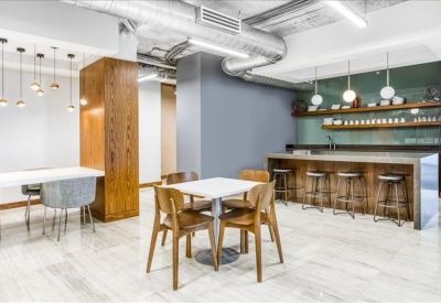 Spacious communal breakroom with a marble kitchen island, bar seating, and warm wood accents.