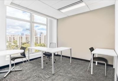 Private corner office with two white desks and large windows overlooking the city.