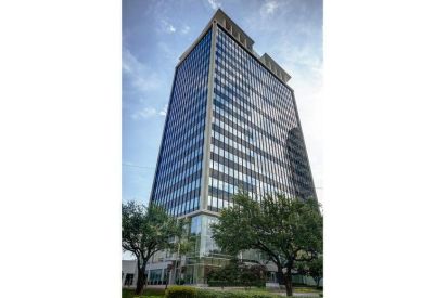 Exterior view of the multi-story glass and stone building at 3838 Oak Lawn Avenue.
