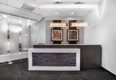 Professional reception desk with textured white paneling and elegant pendant lighting.