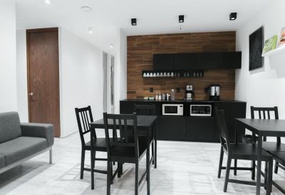 Communal kitchen and dining area with wood-paneled feature wall.