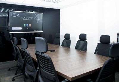 Sleek boardroom with a dark wood table and a large presentation screen.